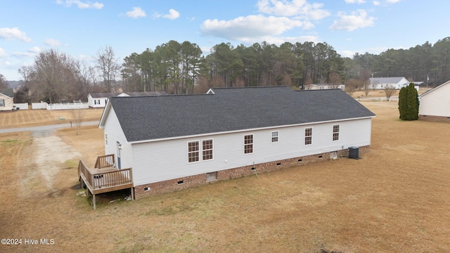 back of property with a wooden deck and a yard