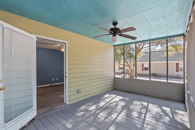 carpeted empty room with ceiling fan and a textured ceiling