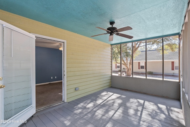 unfurnished sunroom featuring ceiling fan