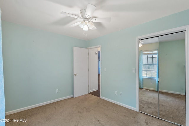 unfurnished bedroom with a ceiling fan, carpet, baseboards, and a closet