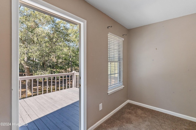 doorway with carpet flooring and baseboards