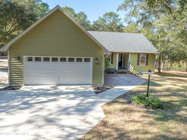 view of front facade with a garage, concrete driveway, and a shingled roof