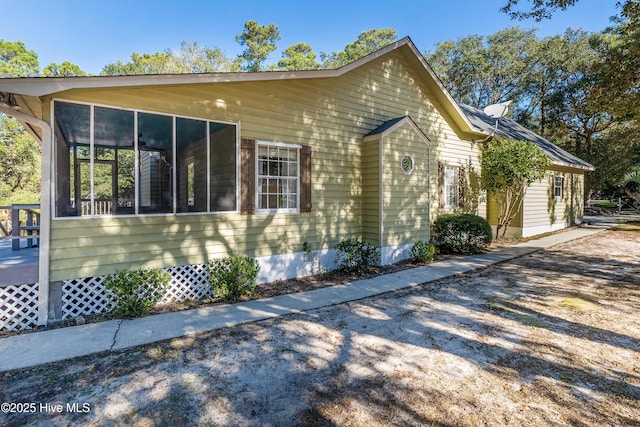 view of property exterior featuring crawl space and a sunroom