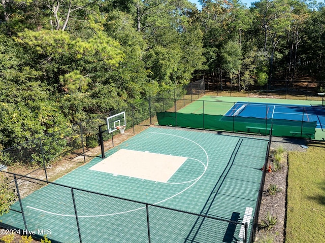 view of basketball court featuring a tennis court, community basketball court, and fence