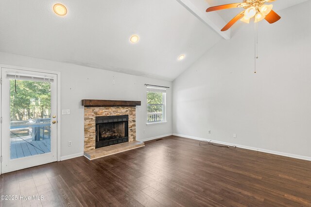 unfurnished living room with lofted ceiling, dark wood-type flooring, and a stone fireplace