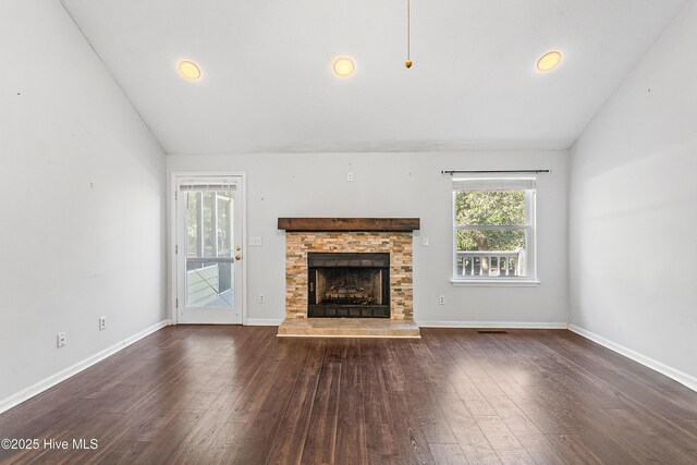 unfurnished living room with dark hardwood / wood-style floors, high vaulted ceiling, a fireplace, beamed ceiling, and ceiling fan