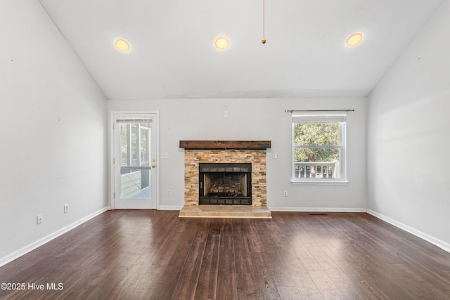 unfurnished living room featuring dark wood finished floors, a fireplace, vaulted ceiling, and baseboards