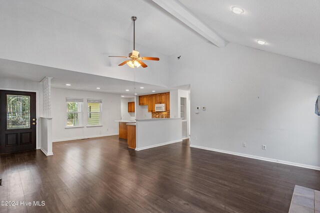 unfurnished living room with ceiling fan, high vaulted ceiling, dark hardwood / wood-style floors, and beamed ceiling