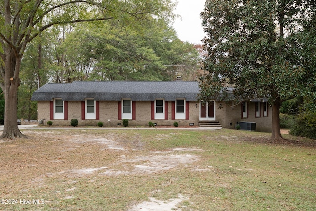 ranch-style home with a front lawn and cooling unit