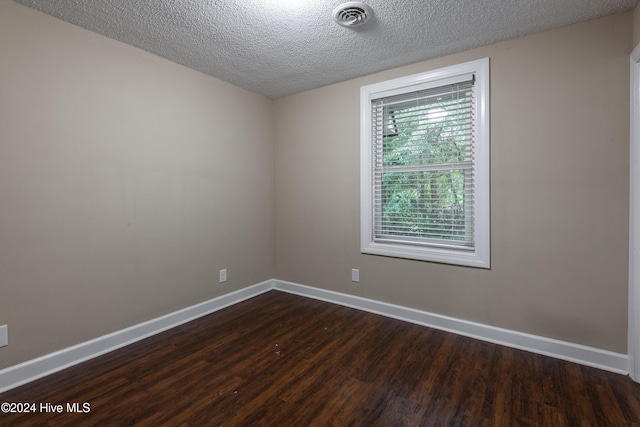 unfurnished room featuring dark hardwood / wood-style floors and a textured ceiling