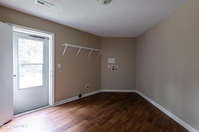 washroom with hookup for an electric dryer, a textured ceiling, hookup for a washing machine, and dark wood-type flooring