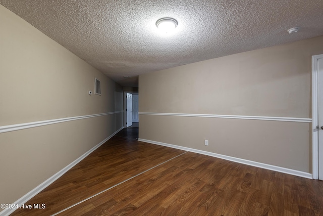 interior space featuring a textured ceiling and dark hardwood / wood-style floors