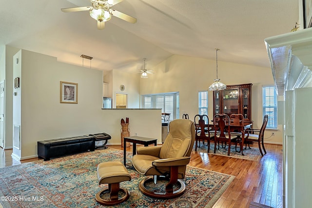 living room featuring vaulted ceiling, ceiling fan, and light wood-type flooring