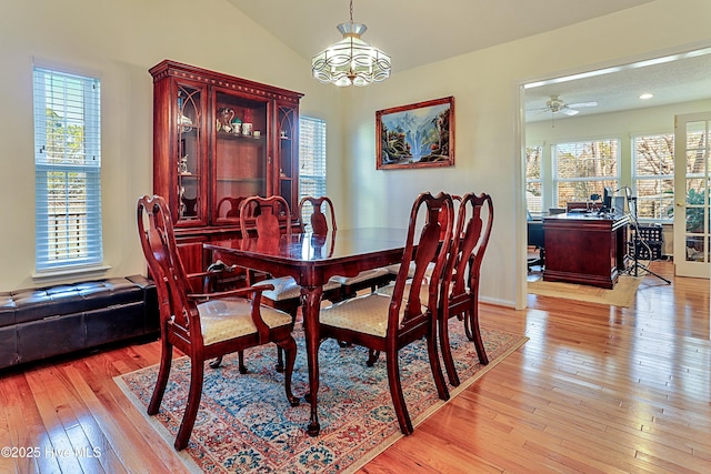 dining room with lofted ceiling, ceiling fan, a healthy amount of sunlight, and light wood-type flooring