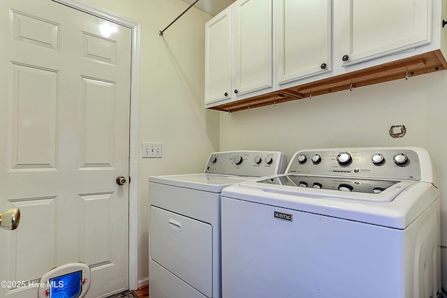 laundry area with washing machine and dryer and cabinets