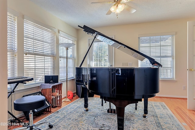 miscellaneous room featuring hardwood / wood-style flooring, ceiling fan, and a textured ceiling