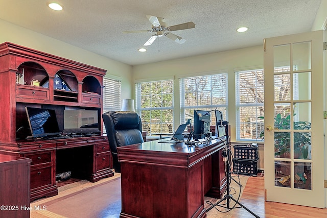 office space featuring a textured ceiling, ceiling fan, and light hardwood / wood-style flooring