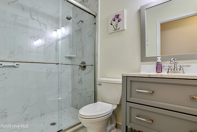 bathroom with vanity, toilet, and a shower with door