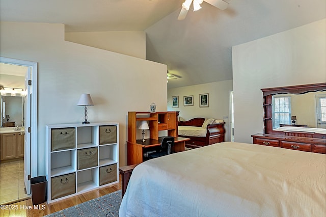 bedroom with lofted ceiling, connected bathroom, sink, light wood-type flooring, and ceiling fan