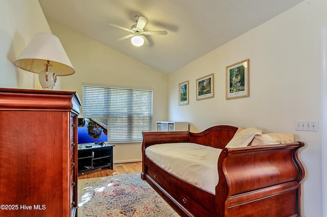 bedroom with ceiling fan, vaulted ceiling, and light hardwood / wood-style flooring