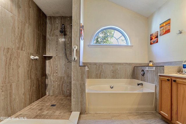 bathroom with independent shower and bath, vanity, tile patterned floors, and a textured ceiling