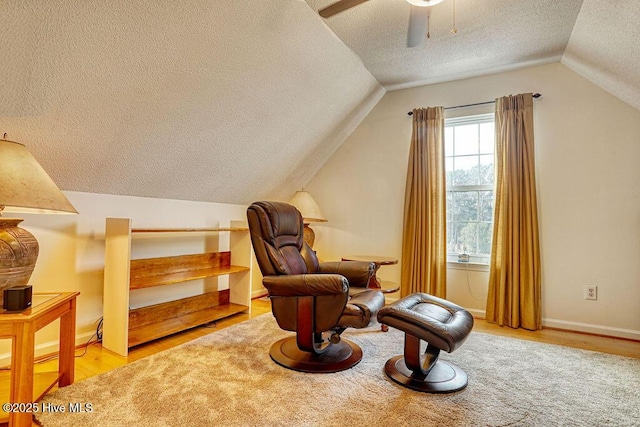 sitting room with vaulted ceiling, ceiling fan, a textured ceiling, and light hardwood / wood-style flooring