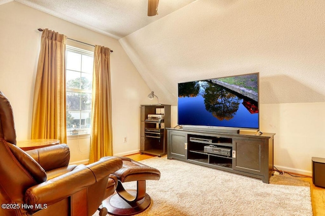 sitting room featuring lofted ceiling, ceiling fan, and a textured ceiling