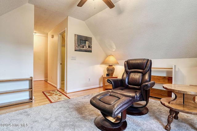 sitting room with ceiling fan, lofted ceiling, a textured ceiling, and light hardwood / wood-style flooring