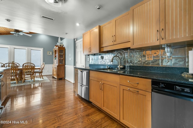 kitchen with sink, dishwasher, dark stone countertops, ceiling fan, and tasteful backsplash