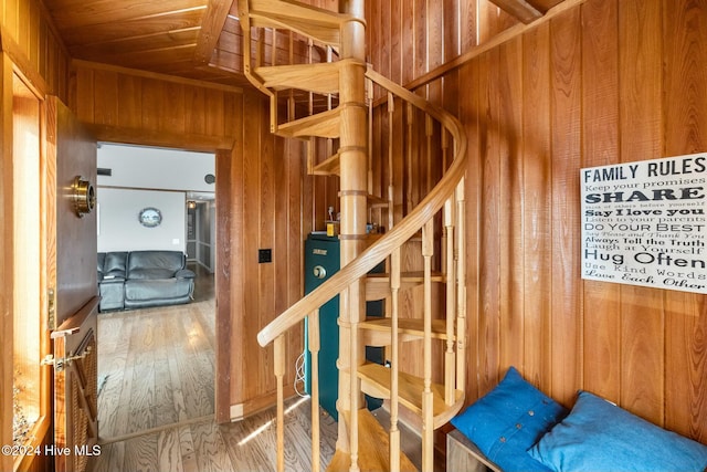 staircase with wooden ceiling, wooden walls, and wood-type flooring