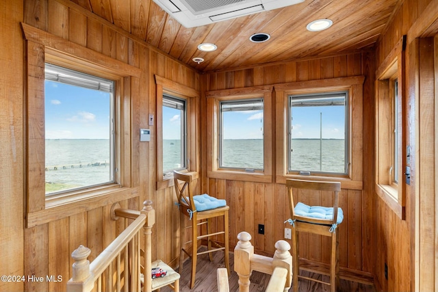 sunroom with a water view and wooden ceiling