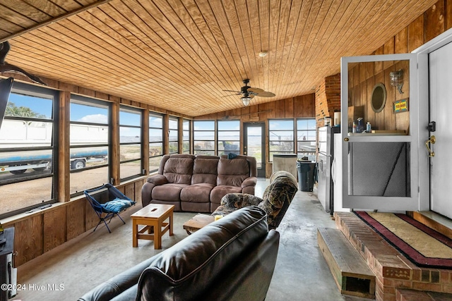 sunroom / solarium featuring lofted ceiling, wooden ceiling, ceiling fan, and a wealth of natural light