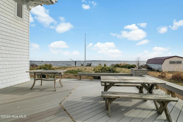 wooden deck with an outbuilding and a water view