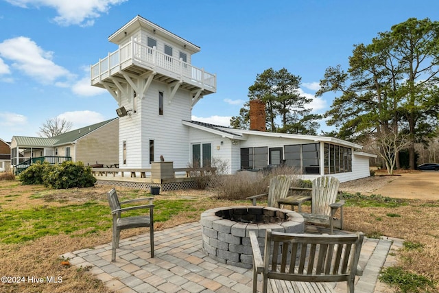 rear view of property with an outdoor fire pit, a balcony, and a patio