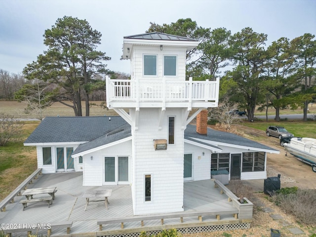 back of property featuring a balcony, a deck, and a sunroom