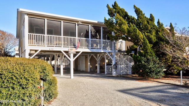 view of front of property with a sunroom and a carport