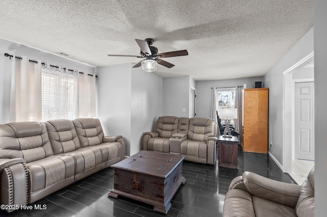 living room featuring ceiling fan and a textured ceiling