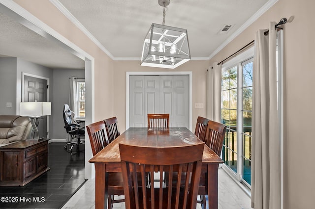 dining area with a chandelier, a textured ceiling, and ornamental molding