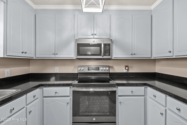 kitchen featuring crown molding, white cabinets, stainless steel appliances, and a textured ceiling