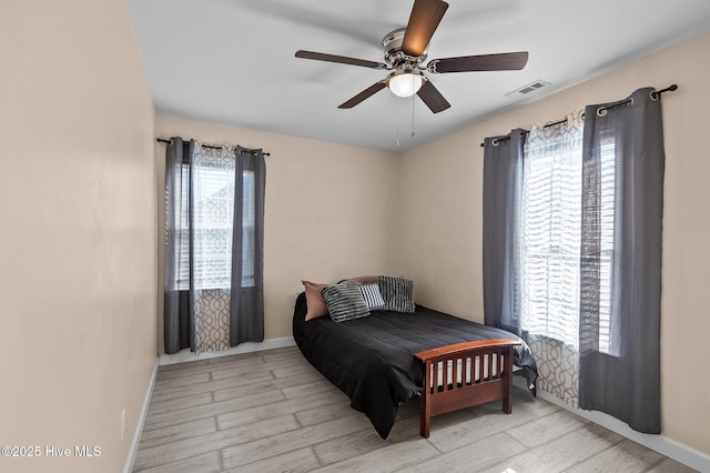 bedroom featuring multiple windows, ceiling fan, and light hardwood / wood-style floors