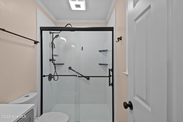 bathroom featuring vanity, toilet, a shower with door, and ornamental molding