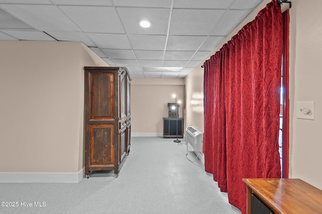 hall with a wall mounted air conditioner and a drop ceiling