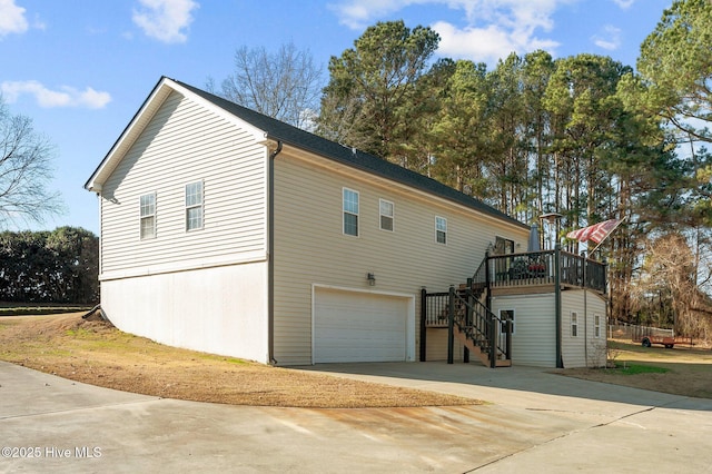 view of side of home featuring a garage and a wooden deck