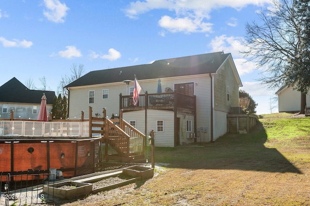 back of property with a lawn and a wooden deck