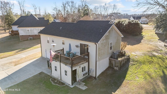 back of house featuring a garage, a yard, and central AC