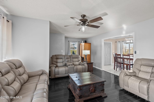 living room featuring ceiling fan and a textured ceiling