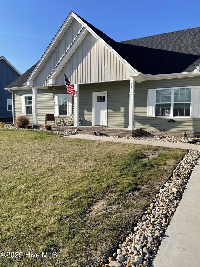 view of front of property with a porch, a garage, and a front yard