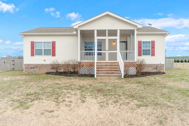 view of front of property featuring a sunroom and a front lawn