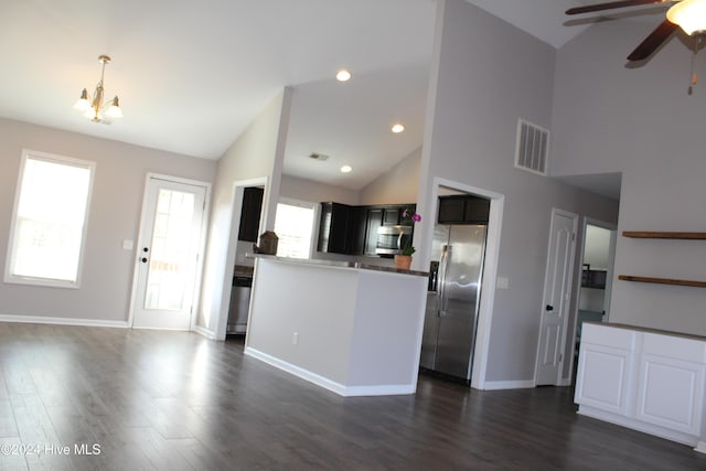 kitchen featuring dark wood-type flooring, high vaulted ceiling, ceiling fan with notable chandelier, kitchen peninsula, and stainless steel appliances