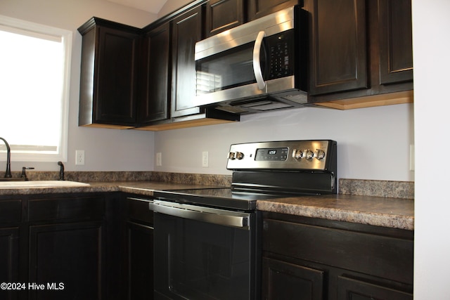 kitchen featuring dark brown cabinets, sink, and appliances with stainless steel finishes